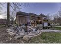 Cozy backyard with a stone fire pit, seating area, and a luxurious hot tub at 12065 Watermark Ct, Indianapolis, IN 46236