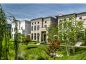 Attractive townhomes with brick facades and black framed windows set amongst green lawns and young trees at 12099 Sigillary Way, Carmel, IN 46032