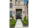 Inviting front door with sidelights, potted plants, and an address marker located above well landscaped flowerbeds at 12099 Sigillary Way, Carmel, IN 46032