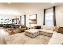 Inviting living room featuring a plush sectional sofa, large windows, and an open layout leading to the dining area at 1221 Herbert St, Indianapolis, IN 46202