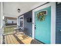 Inviting front porch showcasing a bright turquoise door and outdoor seating area at 1444 English Ave, Indianapolis, IN 46201