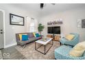 Comfortable living room with modern decor, including a sofa, patterned armchairs, and a flat-screen TV at 1444 English Ave, Indianapolis, IN 46201