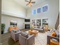 Spacious living room with high ceilings, fireplace, large windows, and stylish furniture arrangement at 14466 Chapelwood Ln, Fishers, IN 46037