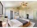 Inviting main bedroom boasts a tray ceiling, neutral décor, ceiling fan, and convenient ensuite bathroom access at 14466 Chapelwood Ln, Fishers, IN 46037