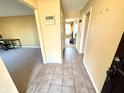 Neutral hallway leads to carpeted living space, featuring tile flooring and neutral wall paint at 1645 Woodview Ln, Anderson, IN 46011