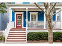 Inviting front porch with a red door, white railings, and comfortable seating area to relax and unwind at 2067 Rhettsbury St, Carmel, IN 46032