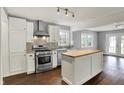 Modern kitchen featuring stainless steel appliances, granite countertops, a butcher block island, and dark wood floors at 214 W Elbert St, Indianapolis, IN 46217