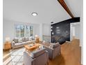 Sunlit living room with hardwood floors, a cozy sofa, armchairs, and an open staircase at 2928 Sheffield Dr, Indianapolis, IN 46229
