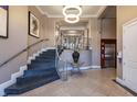 Apartment lobby featuring staircase, modern chandelier, elevator, and decorative flower display at 355 E Ohio St # 221, Indianapolis, IN 46204