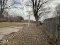 Overcast view of the backyard space with a wooden fence and some leaves at 3812 S Ebright St, Muncie, IN 47302