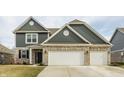 Charming two-story home with brick and siding exterior, a three-car garage and a well-manicured lawn at 4828 W Jamestown Trce, New Palestine, IN 46163