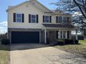 Two-story home with a brick and vinyl exterior and a two-car garage and a well manicured lawn at 6417 E Clarks Hill Ct, Camby, IN 46113