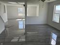 Open-concept living room with gray wood floors, white walls and ceilings, and a ceiling fan at 6417 E Clarks Hill Ct, Camby, IN 46113