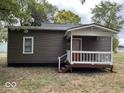 The rear exterior of the home features neutral siding and a charming covered back porch at 709 S Vine St, Muncie, IN 47302