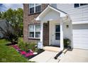 Charming front porch with manicured flowerbeds featuring colorful flowers and an American flag sign at 746 Greene Ct, Avon, IN 46123