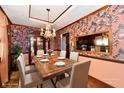 Staged dining room featuring hardwood floors, floral wallpaper, chandelier, table and chairs at 9053 Sunset Ln, Brownsburg, IN 46112