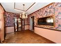 Elegant dining room featuring hardwood floors, floral wallpaper, chandelier and glass display case at 9053 Sunset Ln, Brownsburg, IN 46112