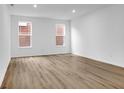 Sunlit bedroom with wood floors, white walls, and two windows providing natural light at 9198 Anthem Ave, Plainfield, IN 46168