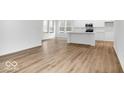 Spacious living room area with wood floors, bright natural light and neutral walls, adjacent to kitchen at 9198 Anthem Ave, Plainfield, IN 46168