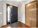 Inviting foyer with hardwood floors, a black front door, and neutral gray walls at 12702 Slippery Rock Rd, Indianapolis, IN 46236
