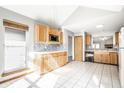 Bright kitchen featuring tile floors, wood cabinets, a mosaic backsplash and stainless steel appliances at 12702 Slippery Rock Rd, Indianapolis, IN 46236