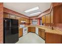 Traditional kitchen featuring wood cabinets, laminate countertops, and white appliances at 138 President W Trl, Indianapolis, IN 46229