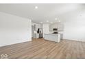 Bright open-concept kitchen with stainless steel appliances, quartz countertops and hardwood flooring, flowing into the living area at 17293 Rancorn Pl, Westfield, IN 46074