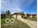 Single-story home with an attached garage and driveway on a sunny day at 1836 Queensbridge N Cir, Indianapolis, IN 46219