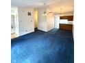Inviting living room with blue carpeting, neutral walls, and access to the kitchen at 1836 Queensbridge N Cir, Indianapolis, IN 46219