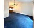 Open living room featuring blue carpeting and a ceiling fan at 1836 Queensbridge N Cir, Indianapolis, IN 46219