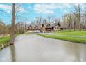 View of the home and garage with a picturesque pond in the foreground at 222 Stony Ln, Noblesville, IN 46060