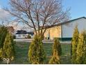 Exterior view of the home, surrounded by green trees and a large garage/storage building at 2275 N 250 E, Lebanon, IN 46052
