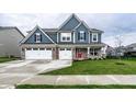 Beautiful blue two-story home featuring a three-car garage and a well-manicured front lawn at 3164 Kent Dr, Brownsburg, IN 46112