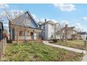 Charming blue two-story home with front porch surrounded by a green lawn at 324 W 7Th St, Anderson, IN 46016