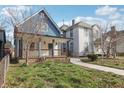 Charming blue two-story home with front porch surrounded by a green lawn at 324 W 7Th St, Anderson, IN 46016
