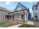 Close-up of a charming blue two-story home featuring a spacious, covered front porch at 324 W 7Th St, Anderson, IN 46016