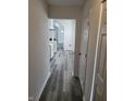 Bright hallway featuring modern gray floors leading to a well-lit kitchen and open living space at 3614 N Capitol Ave, Indianapolis, IN 46208