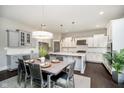 Bright dining area showcasing a stylish table set, elegant chandelier, and a seamless transition to the modern kitchen at 3989 Birkdale Dr, Carmel, IN 46033