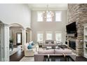 Spacious living room with a stone fireplace, soaring ceilings, and abundant natural light at 3989 Birkdale Dr, Carmel, IN 46033