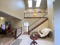 Inviting entryway with high ceilings, a wooden staircase, and a cozy chaise lounge for a warm welcome at 4140 Melbourne Rd, Indianapolis, IN 46228