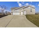Spacious three-car garage showcasing a long driveway and well-maintained landscaping at 6672 Eagles Nest Ln, McCordsville, IN 46055