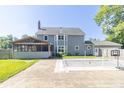 View of the home's rear exterior, screened porch, swimming pool and spacious yard at 7372 Deerfield Dr, Greenfield, IN 46140