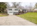 Well-maintained home with a long driveway and beautifully landscaped front yard at 7806 Meadowbrook Dr, Indianapolis, IN 46240