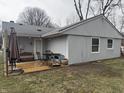 The back of the house with an outdoor patio set on a wooden deck and green backyard at 1016 Alden Dr, Fortville, IN 46040