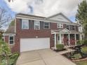 A beautiful brick two-story home with a two-car garage and a well-manicured front yard on a sunny day at 10343 Waveland Cir, Fishers, IN 46038