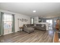 Inviting living room featuring hardwood floors, large sectional and access to dining area at 10946 Snowdrop Way, Indianapolis, IN 46235