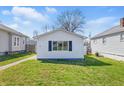 Charming home with white siding, a well-manicured lawn, and a quaint walkway to the front door at 1135 E Southern Ave, Indianapolis, IN 46203