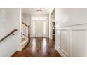 Bright foyer with hardwood floors, staircase and white wainscoting at 12895 Grenville St, Carmel, IN 46032