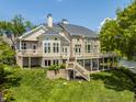 Elegant multi-story home with a large deck, manicured lawn, and sophisticated architectural details at 1326 White Water Ct, Cicero, IN 46034