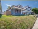 A quaint single-Gathering home with a welcoming front porch, set against a backdrop of a sunny day at 1327 E Minnesota St, Indianapolis, IN 46203